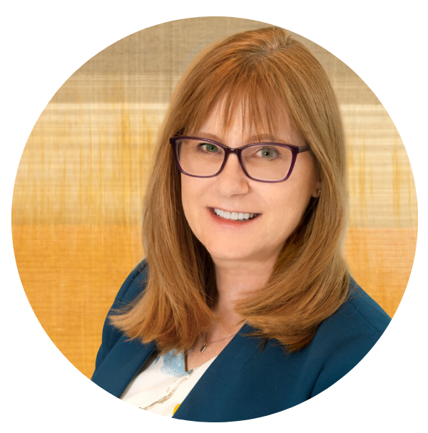 Eve Hill headshot. White woman with medium length red hair and dark rimmed glasses smiling.